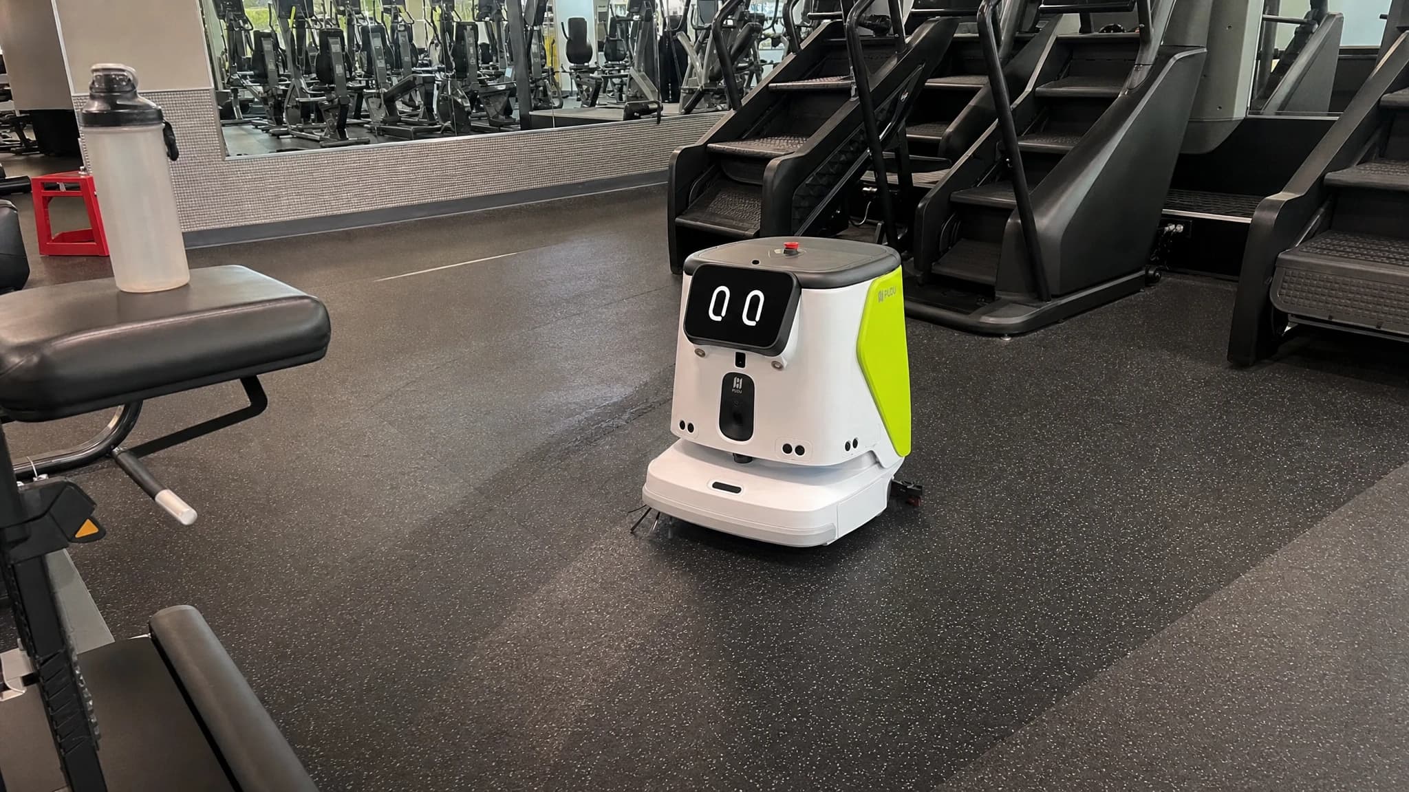 A compact cleaning robot between gym equipment rows