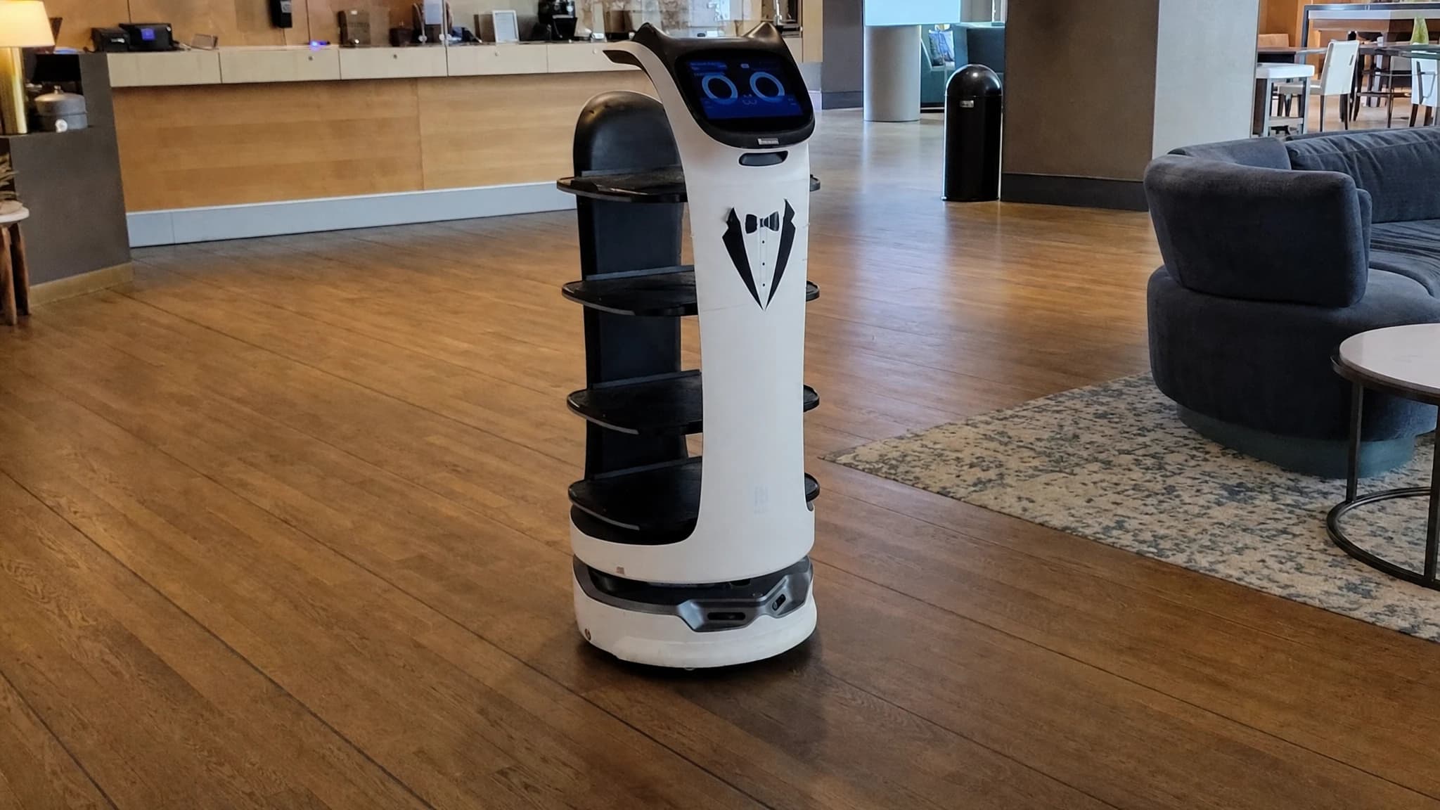 A tray-carrying delivery robot working a hotel floor