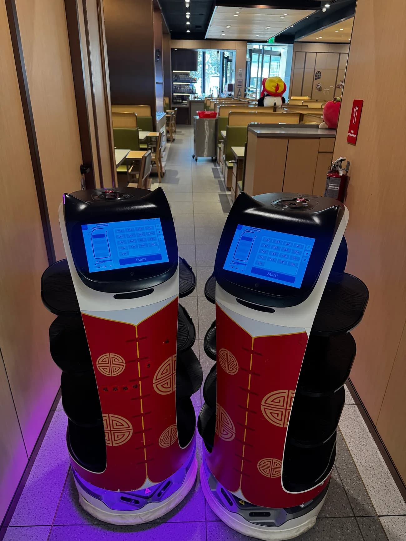 The delivery robot running plates through a full dining room at Haidilao San Diego