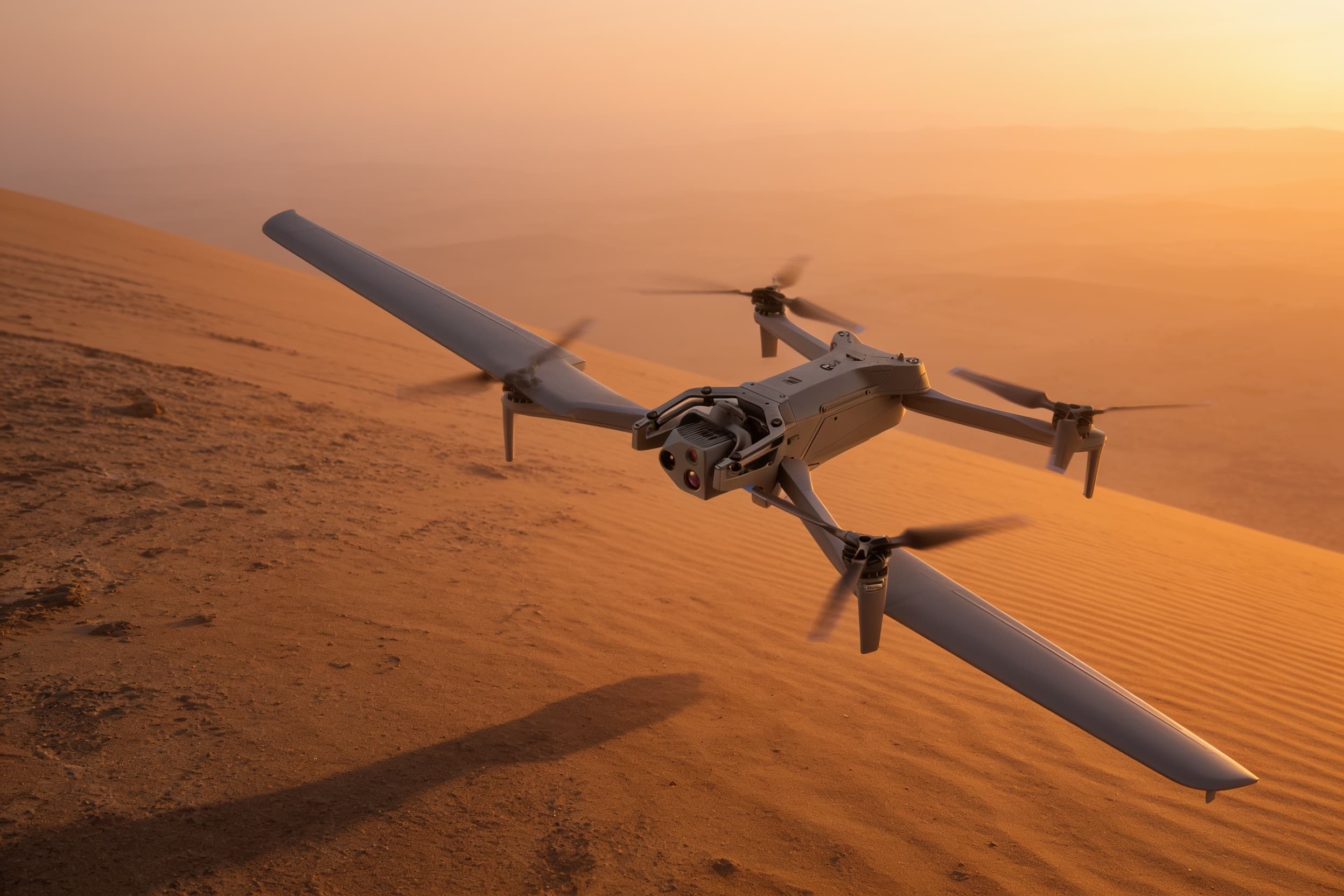 Fixed-wing drone high over desert terrain at sunset
