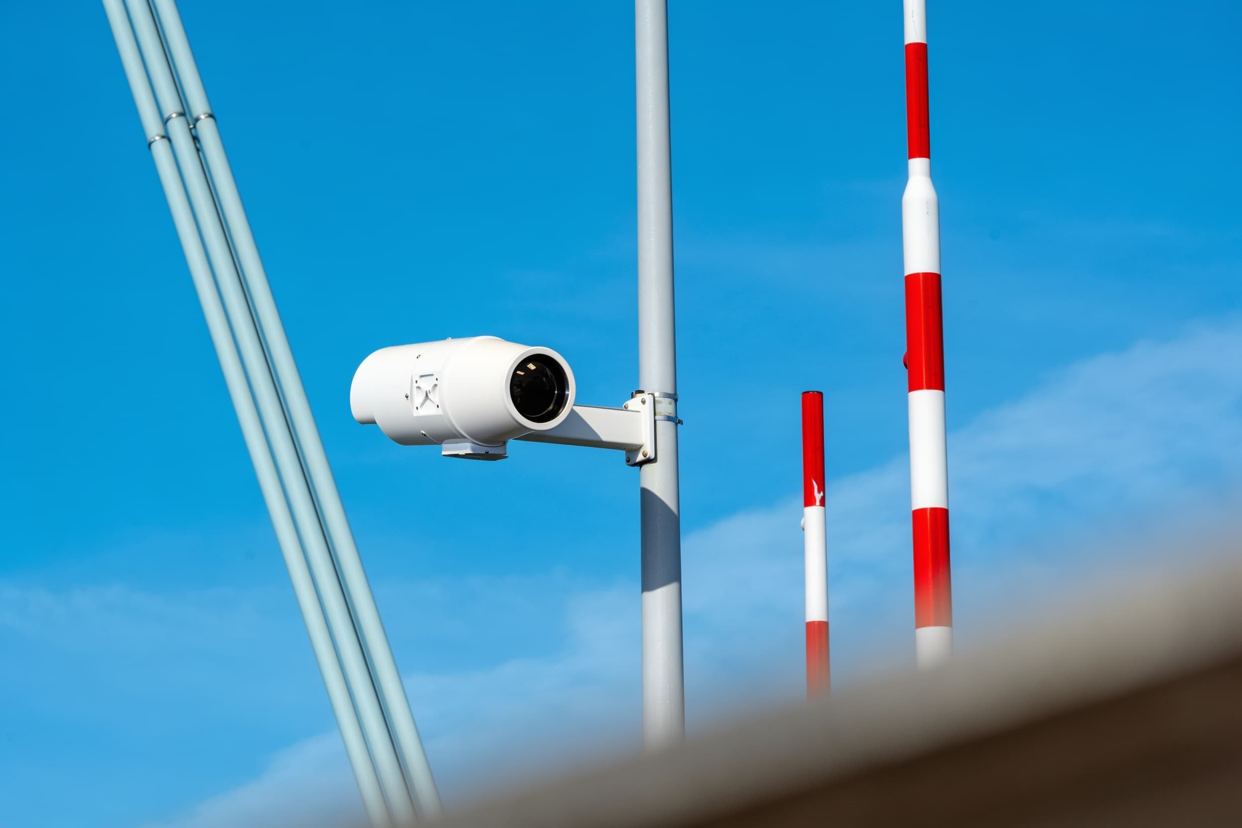 A security camera mounted on the mast against the sky