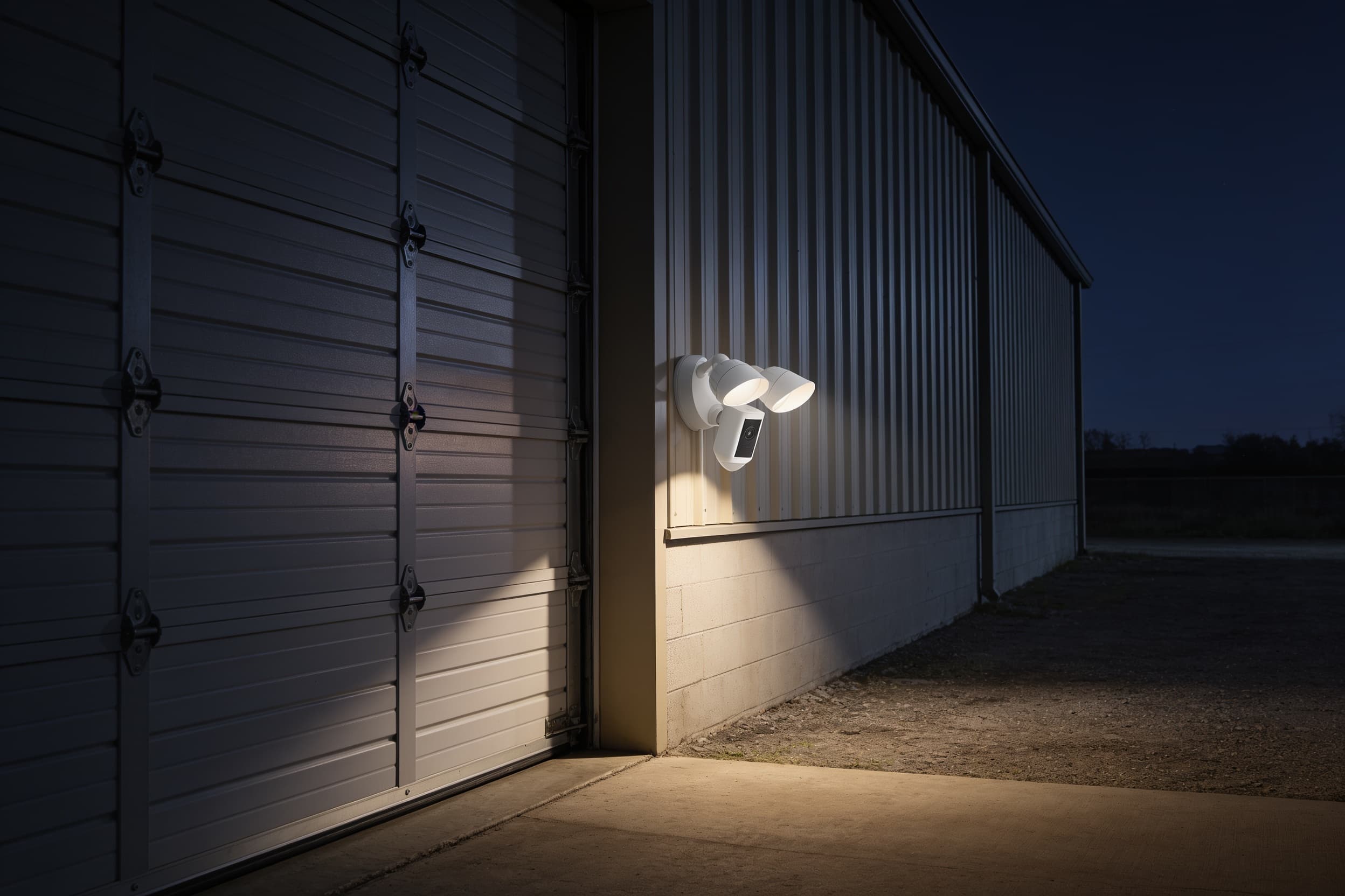 Floodlight camera on a warehouse corner at night
