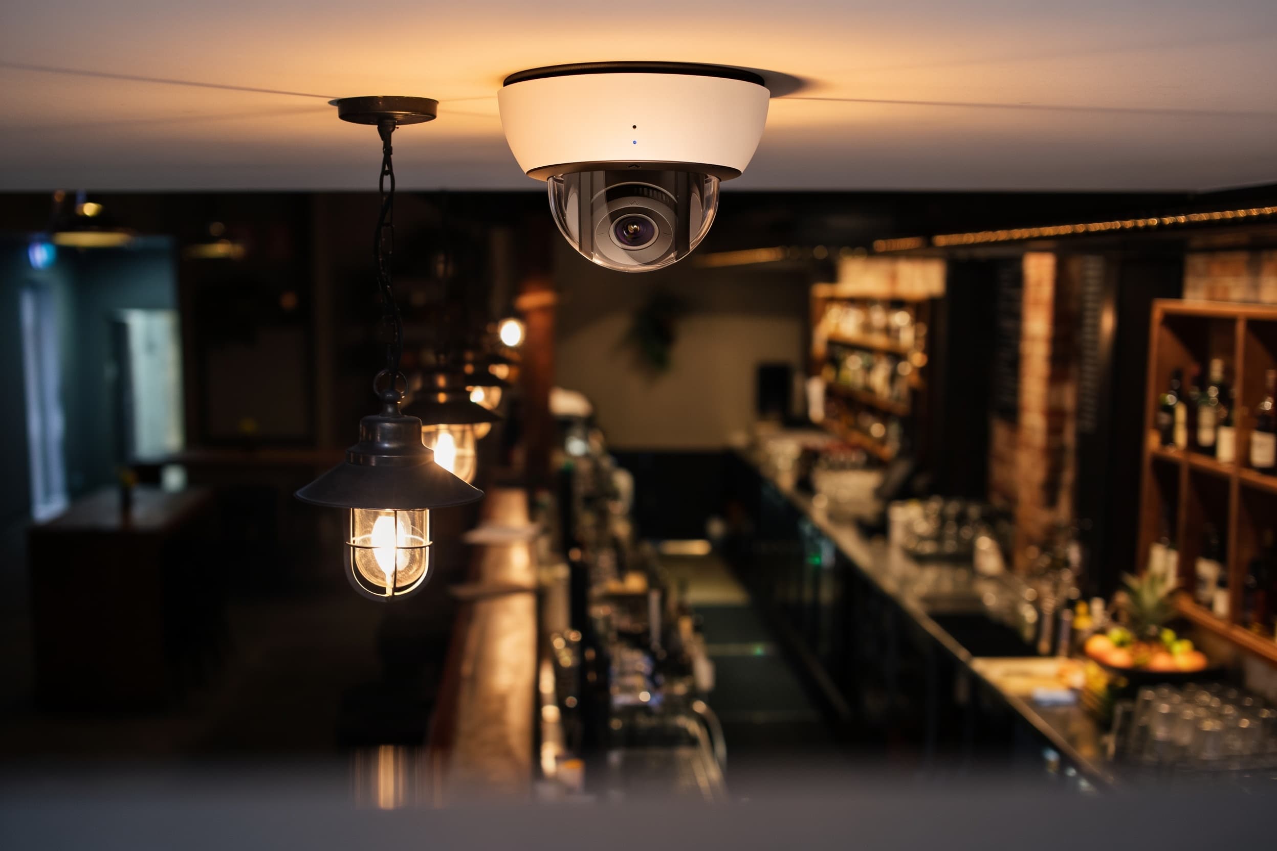 A security camera ceiling-mounted above the bar area
