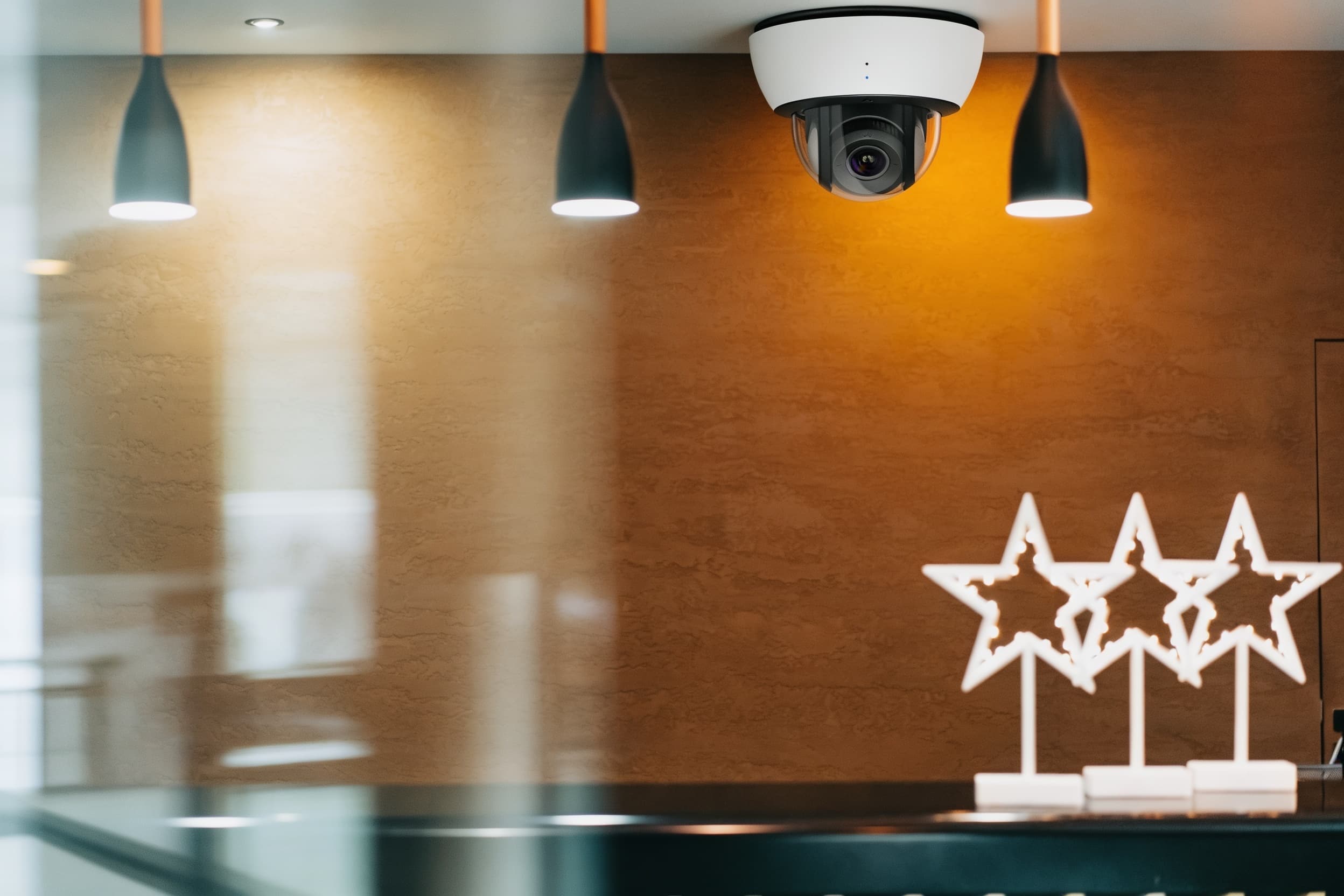 A ceiling security camera overlooking a hotel lobby reception
